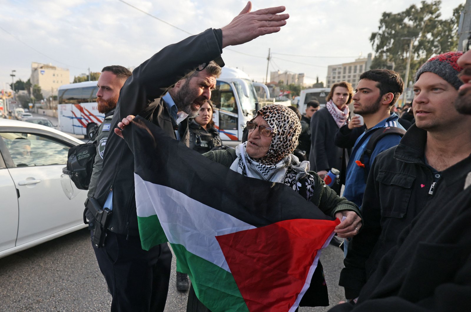 A Palestinian woman deploys a flag as she takes part in a demonstration in East Jerusalem, Palestine, Jan. 13, 2023. (AFP Photo)