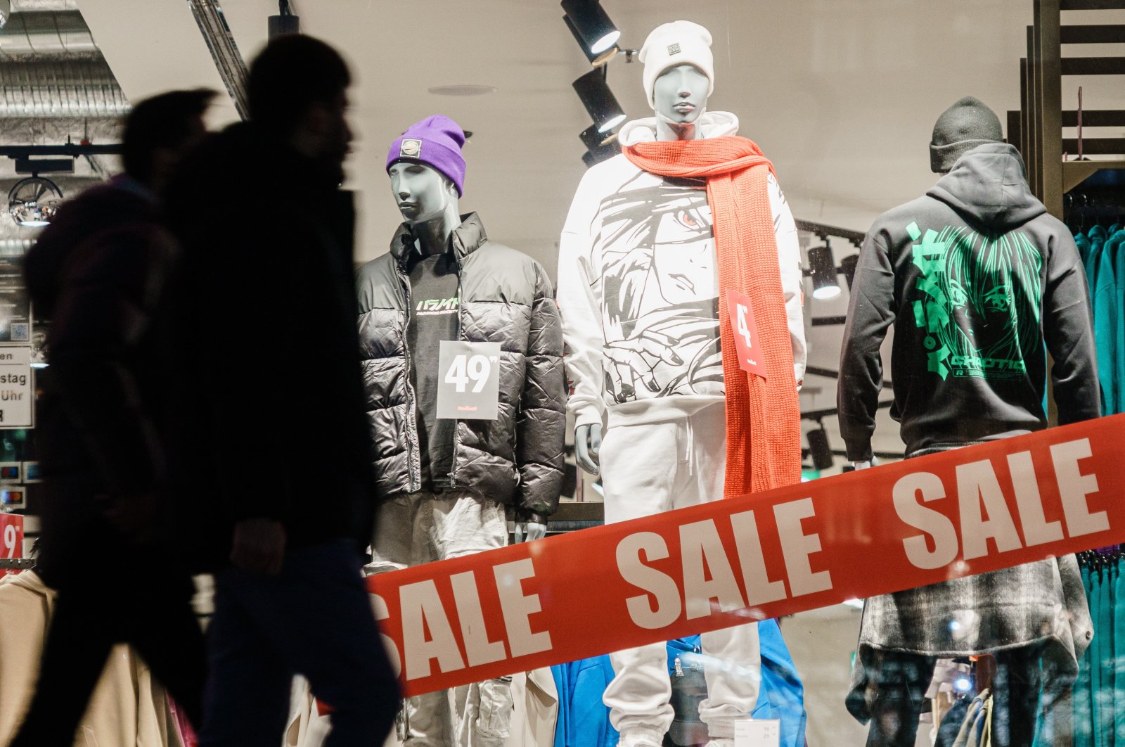 Passers-by walk in front of a shopping window reading &quot;sale&quot; in Berlin, Germany, Jan. 5, 2023. (EPA Photo)