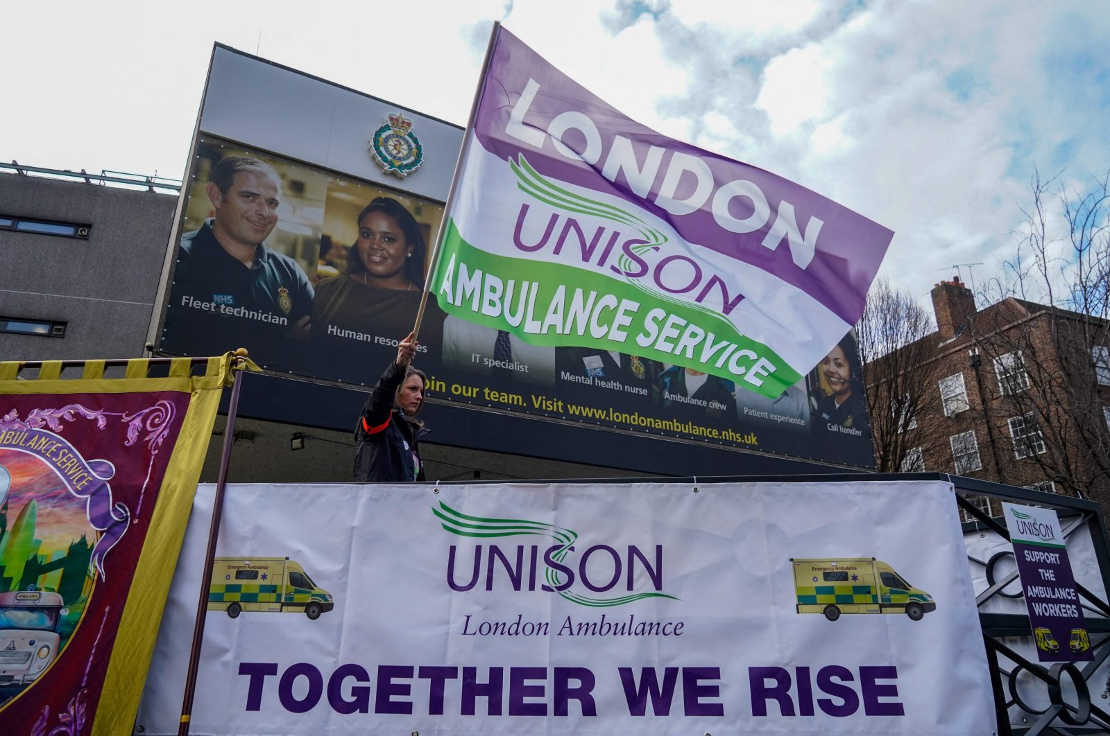 An ambulance worker waves a flag at a picket line outside the Waterloo ambulance station in London, UK, Dec. 21, 2022. (AFP Photo)