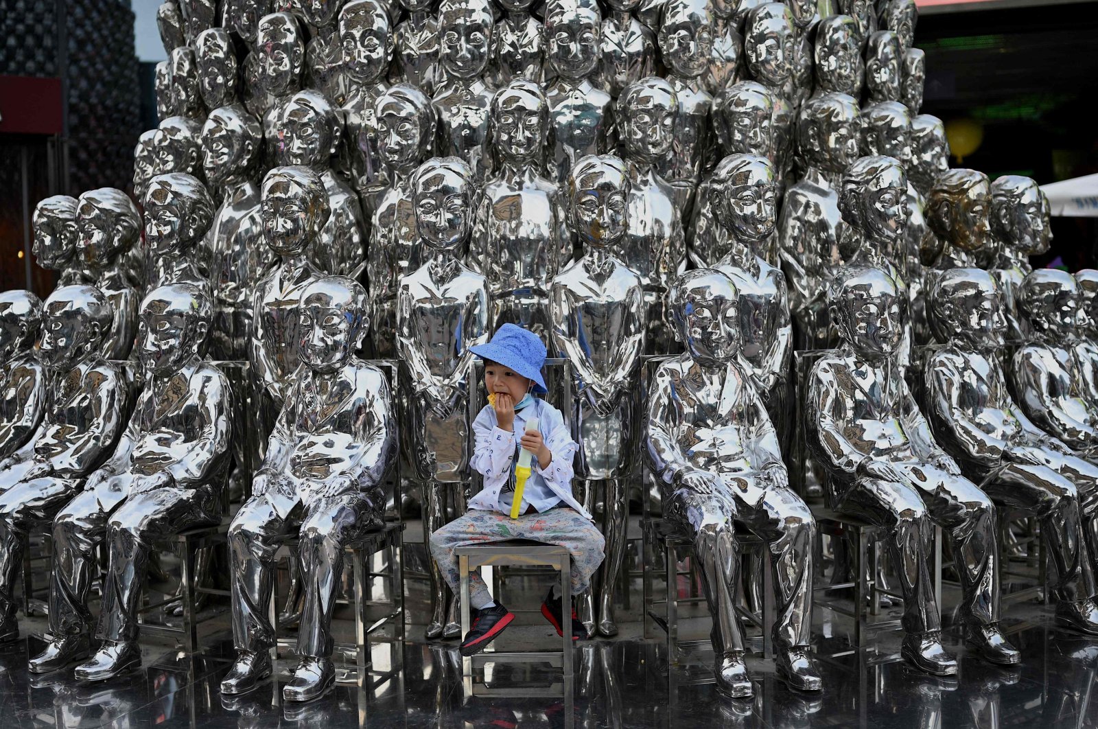 A boy sits on a chair amongst sculptures on display at a shopping center on International Children&#039;s Day in Beijing, June 1, 2021. (AFP Photo)