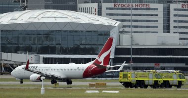 A Qantas jet is parked on the tarmac next to firetrucks at Sydney International Airport after making an emergency landing in Sydney, Australia, Jan. 18, 2023. (AP Photo)