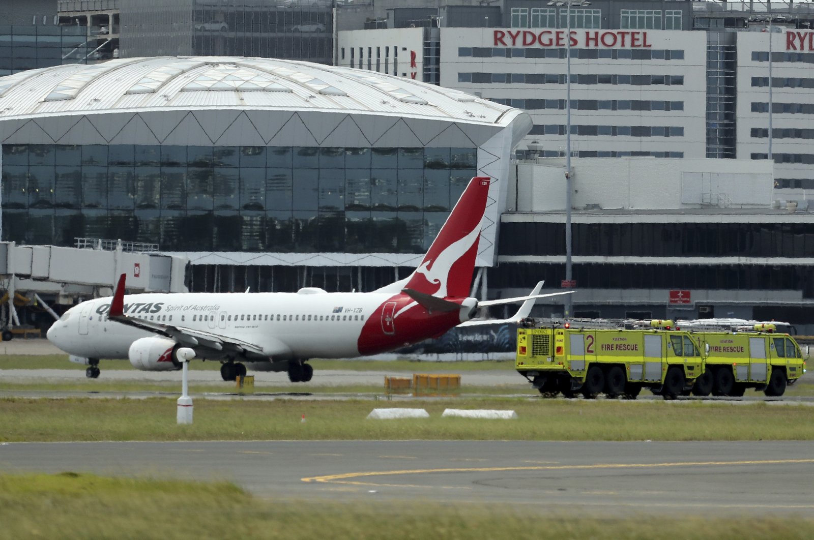 A Qantas jet is parked on the tarmac next to firetrucks at Sydney International Airport after making an emergency landing in Sydney, Australia, Jan. 18, 2023. (AP Photo)