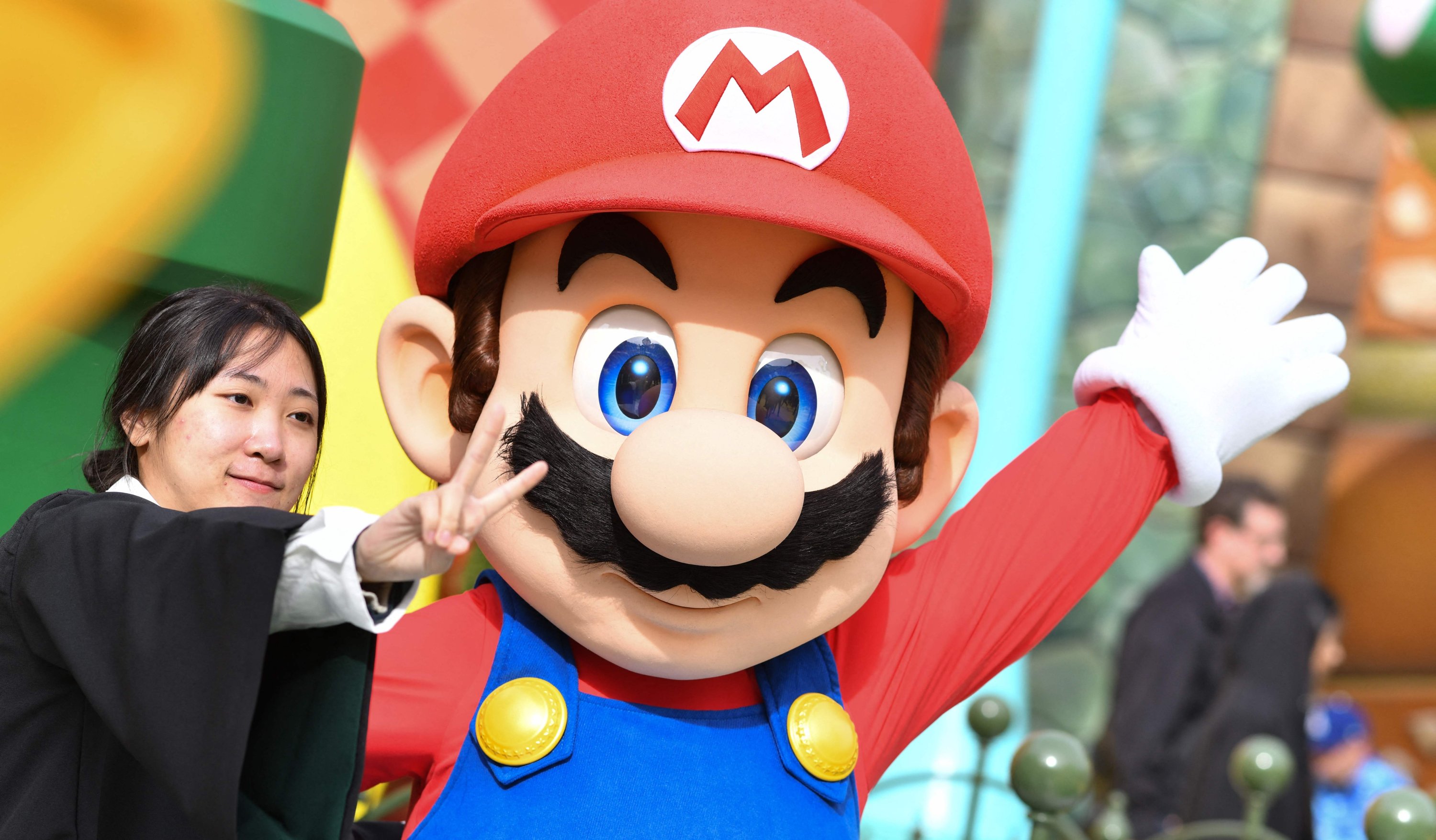 Seorang tamu berfoto dengan Mario saat pratinjau Super Nintendo World di Universal Studios di Los Angeles, California, AS, 13 Januari 2023. (AFP Photo)