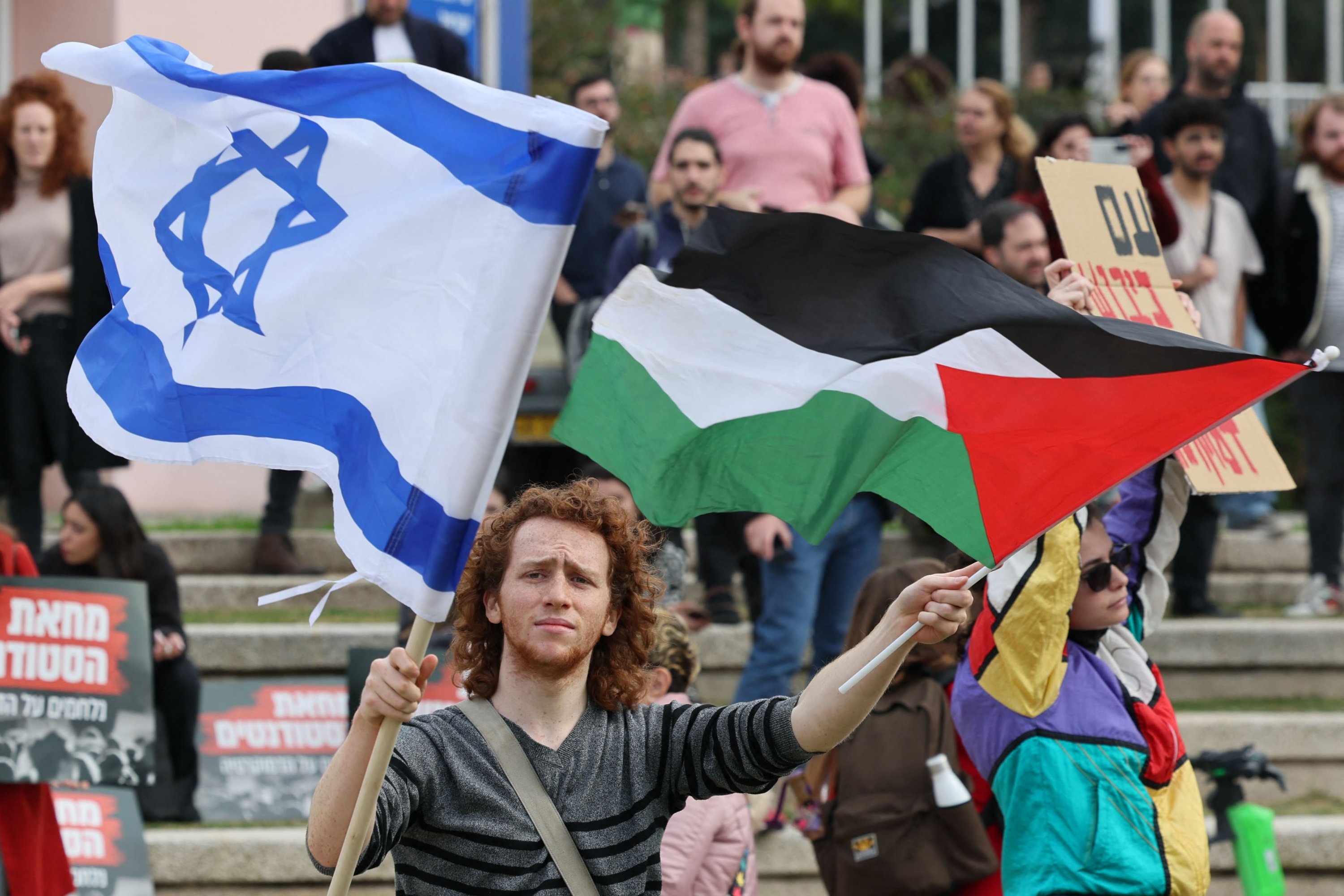 Pelajar Israel memegang bendera Palestina dan Israel selama demonstrasi menentang pemerintahan baru sayap kanan Perdana Menteri Benjamin Netanyahu, Tel Aviv, Israel, 16 Januari 2023. (AFP Photo)