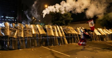 A woman waves a Peruvian flag in front of riot police to demonstrate against Peru&#039;s President Dina Boluarte, in Lima, Peru, Jan. 20, 2023. (Reuters Photo)