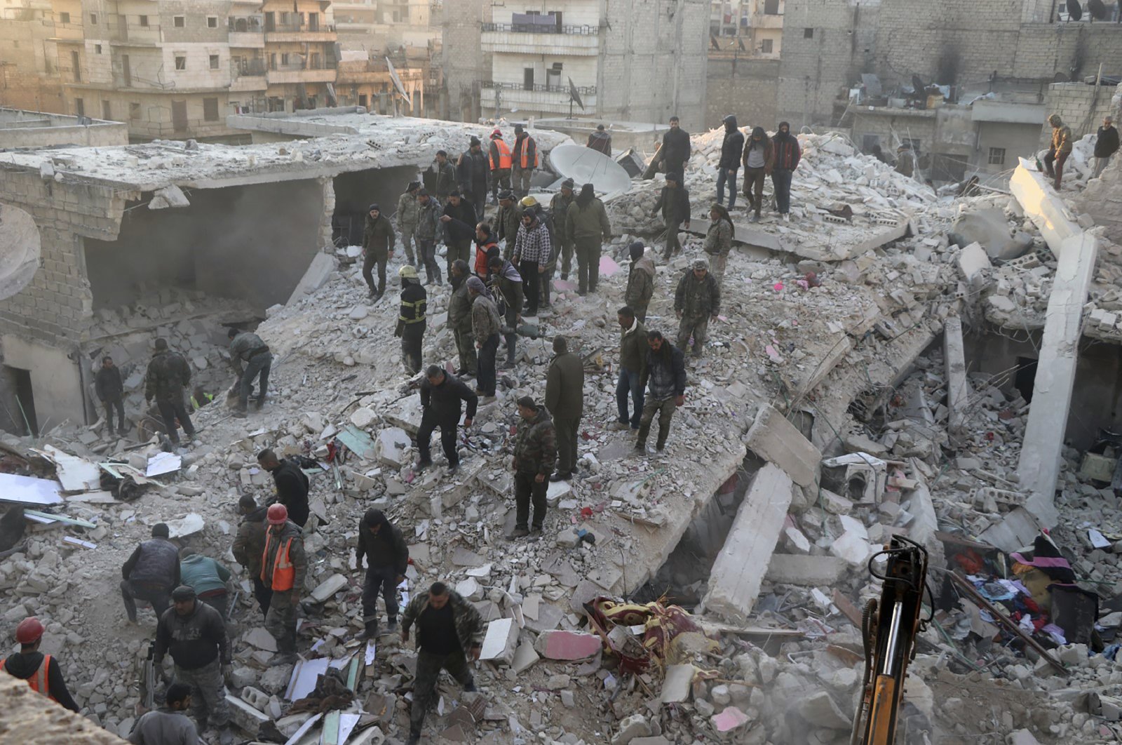 Civil defense workers and civilians work on the rubble of a destroyed building in the Sheikh Maksoud neighborhood in Aleppo, Syria, Jan. 22, 2023. (AP Photo)
