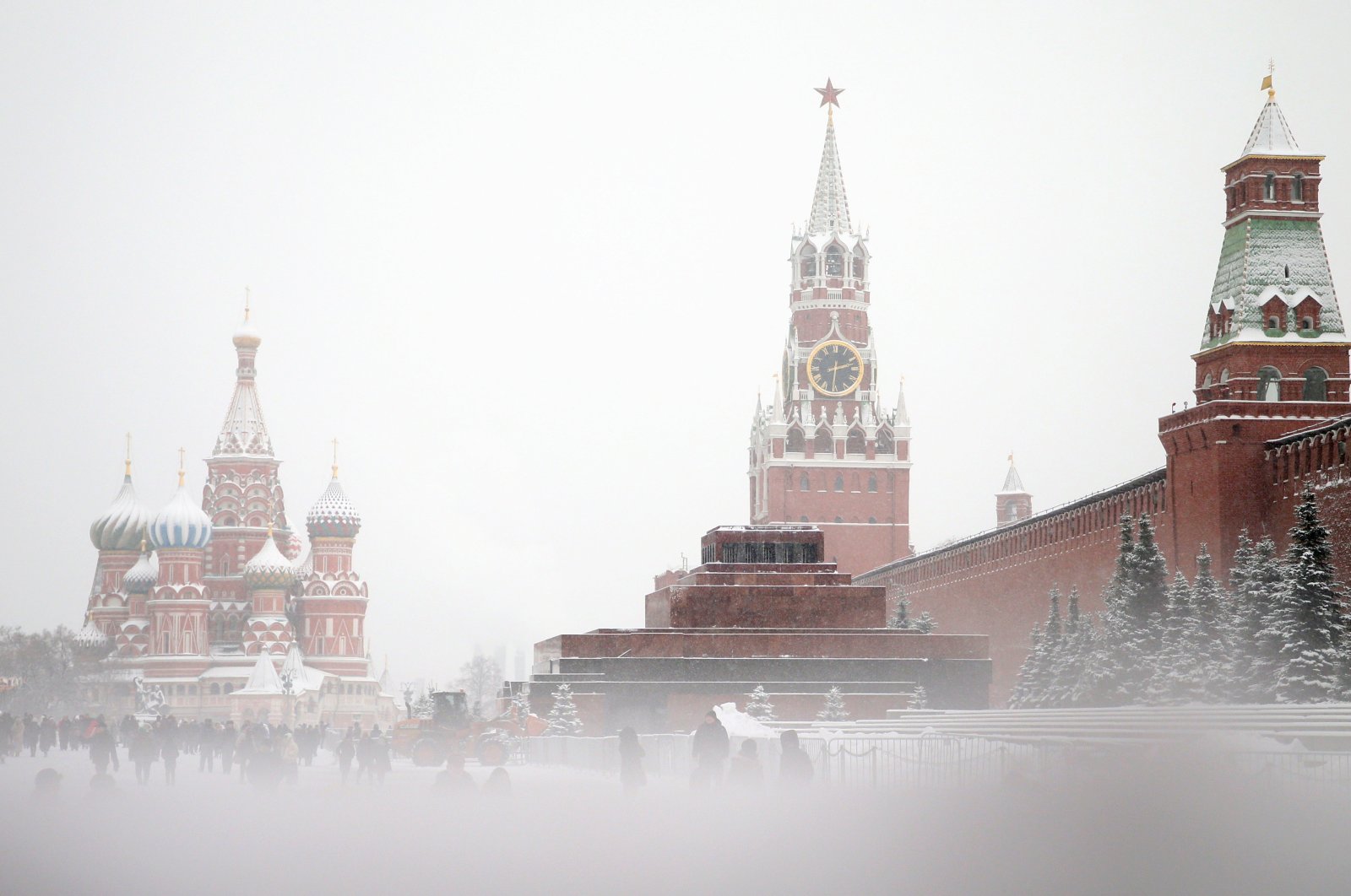 People walk on the Red Square in front of the Kremlin during snowfall in downtown Moscow, Russia, Dec. 28, 2022. (EPA Photo)