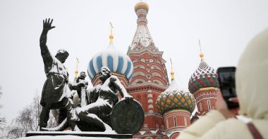 A woman takes a photo of the Monument to Minin and Pozharsky, and the St. Basil's Cathedral at the Red Square, Moscow, Russia, Dec. 28, 2022. (EPA Photo)