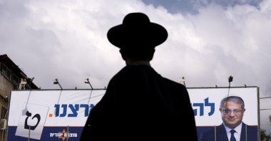 A man walks by an election campaign billboard showing Itamar Ben-Gvir, Israel’s newly elected far-right National Security Minister, Bnei Brak, Israel, Oct. 24, 2022. (AP Photo)