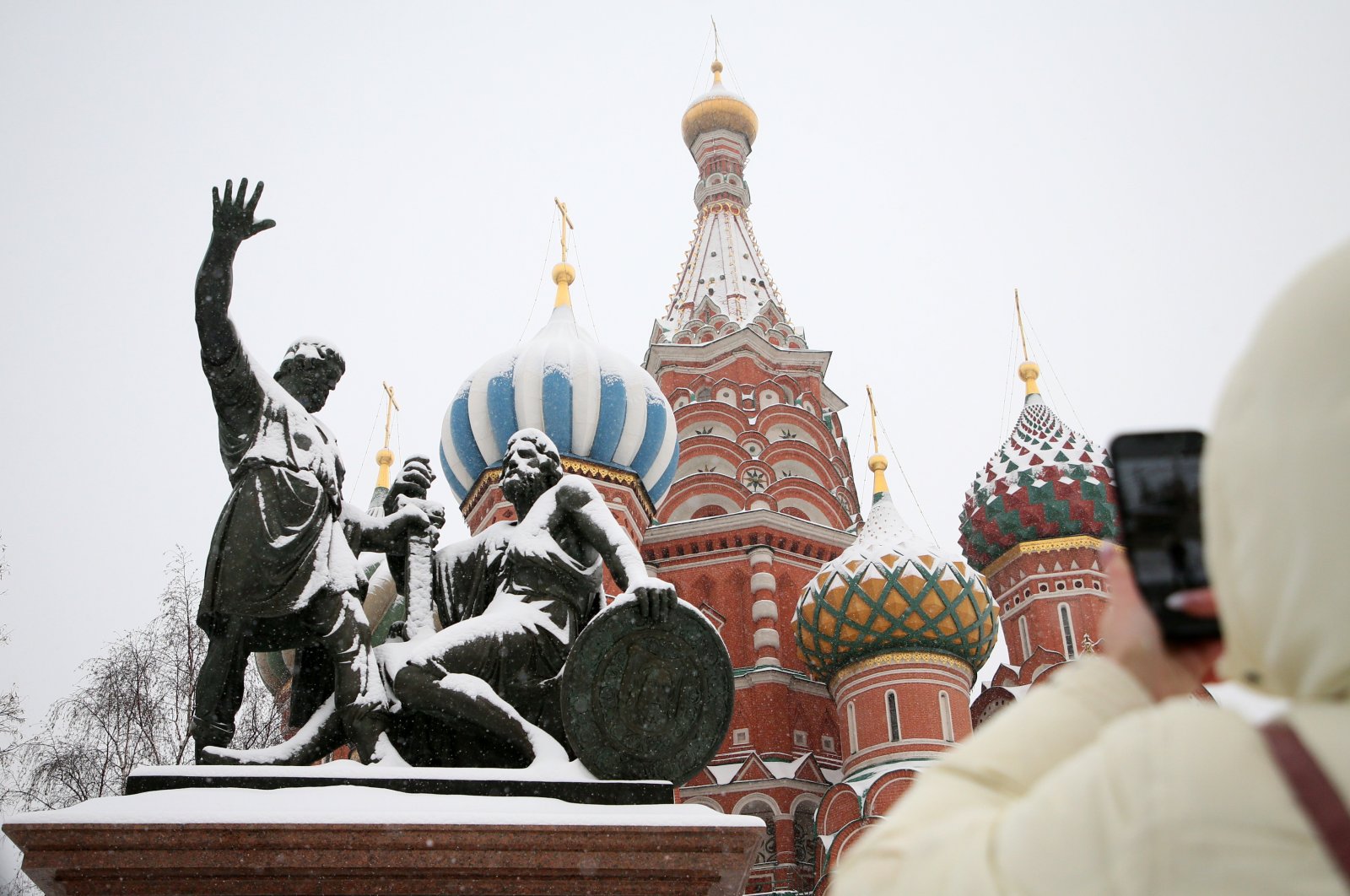 A woman takes a photo of the Monument to Minin and Pozharsky, and the St. Basil&#039;s Cathedral at the Red Square, Moscow, Russia, Dec. 28, 2022. (EPA Photo)
