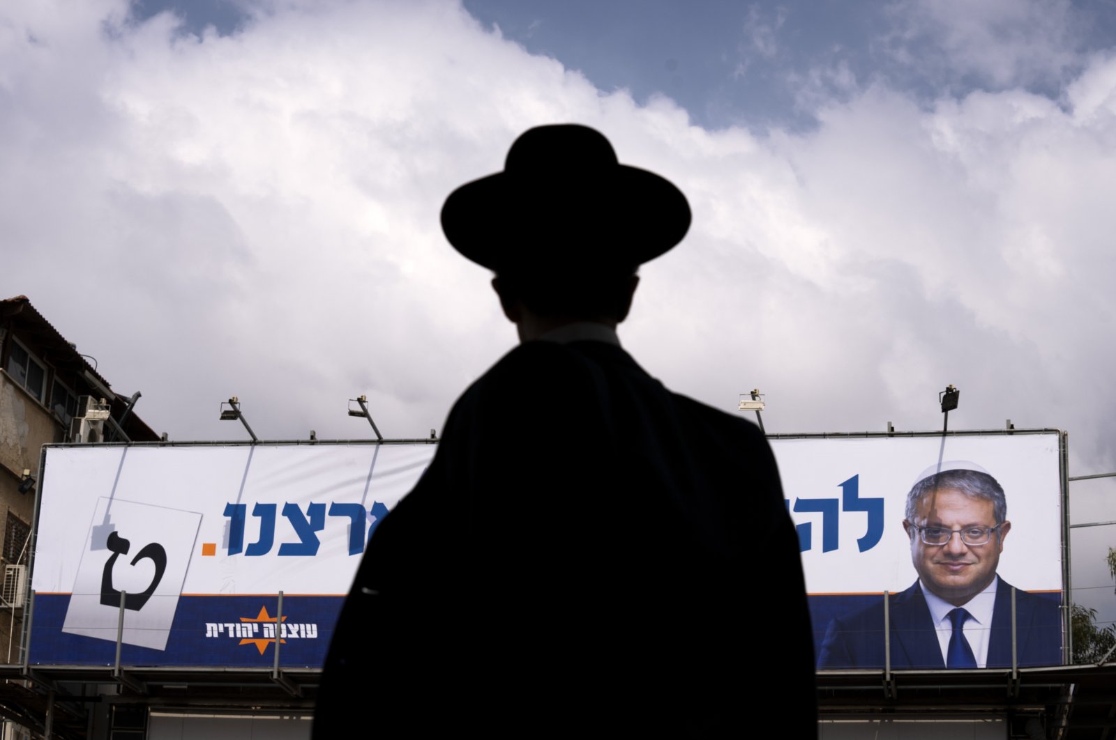 A man walks by an election campaign billboard showing Itamar Ben-Gvir, Israel’s newly elected far-right National Security Minister, Bnei Brak, Israel, Oct. 24, 2022. (AP Photo)
