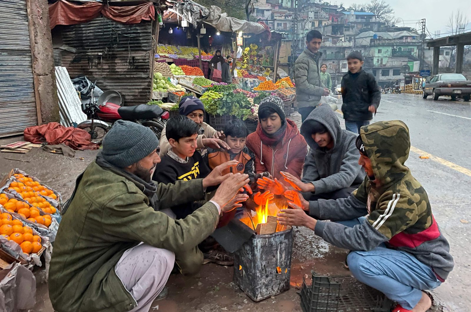 Vendors warm themselves as they light a bonfire at a market during a nationwide power outage, Muzaffarabad, Pakistan, Jan. 23, 2023. (AFP Photo)