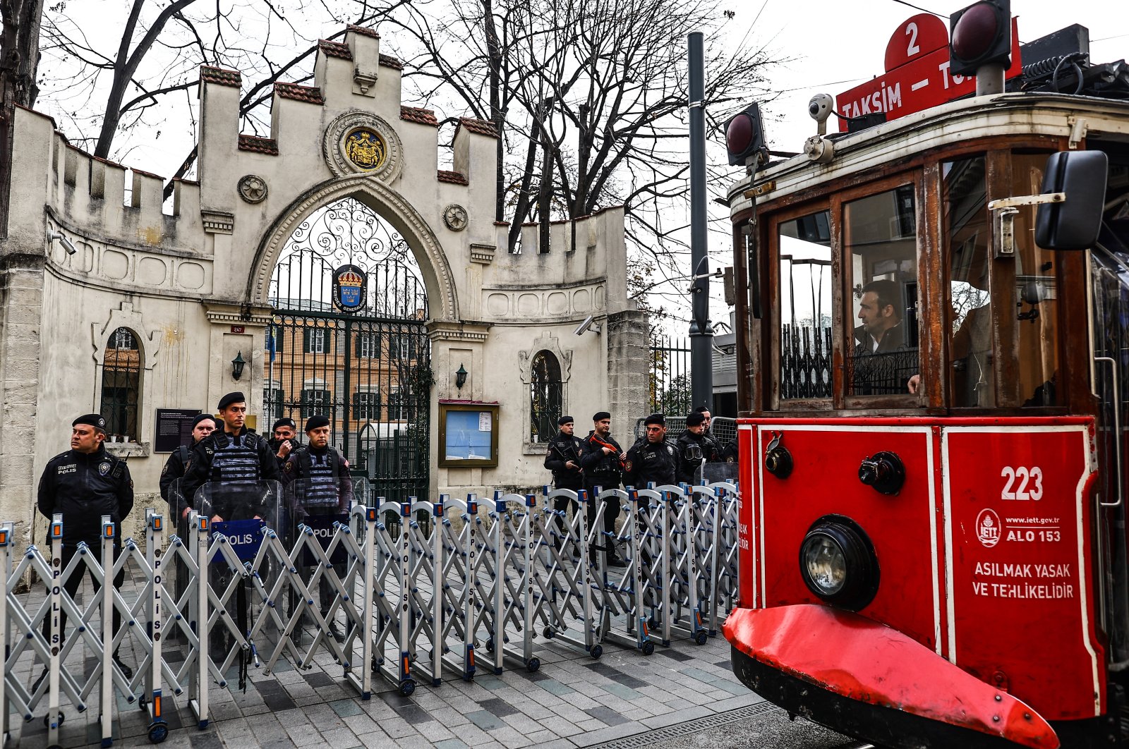 Turkish riot police stand guard before a protest while a nostalgic tram passes in front of the Consulate General of Sweden, in Istanbul, Türkiye, Jan. 22, 2023. (EPA Photo)