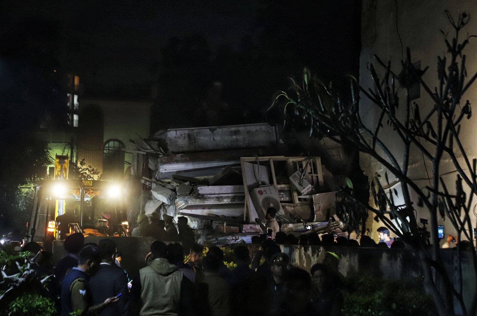 Rescue teams search for survivors on the debris of a residential building that collapsed in Lucknow on Jan. 24, 2023. (AFP Photo)