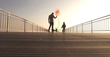 A dad and a son fly a kite, at Avcılar district, in Istanbul, Türkiye, Feb. 18, 2018. (Shutterstock Photo)