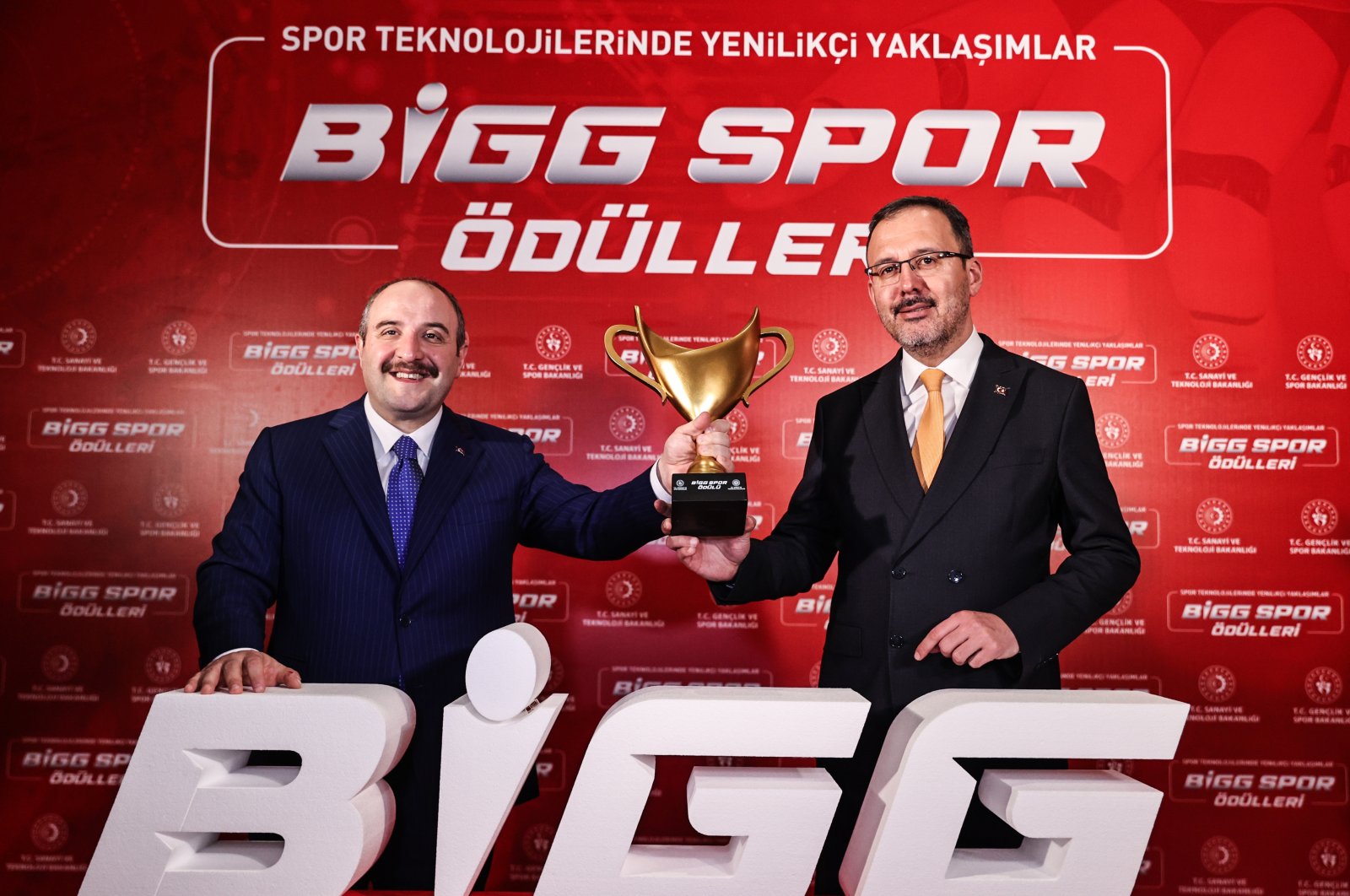 Türkiye&#039;s Industry and Technology Minister Mustafa Varank (L) and Youth and Sports Minister Mehmet Muharrem Kasapoğlu (R) holding up a BIGG Sports Awards trophy at Atatürk Cultural Center, Istanbul, Türkiye, Jan. 24, 2023. (AA Photo)