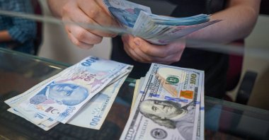 A man at the exchange office counts Turkish lira banknotes in Ankara, Türkiye, Jan. 13, 2022. (Reuters Photo)