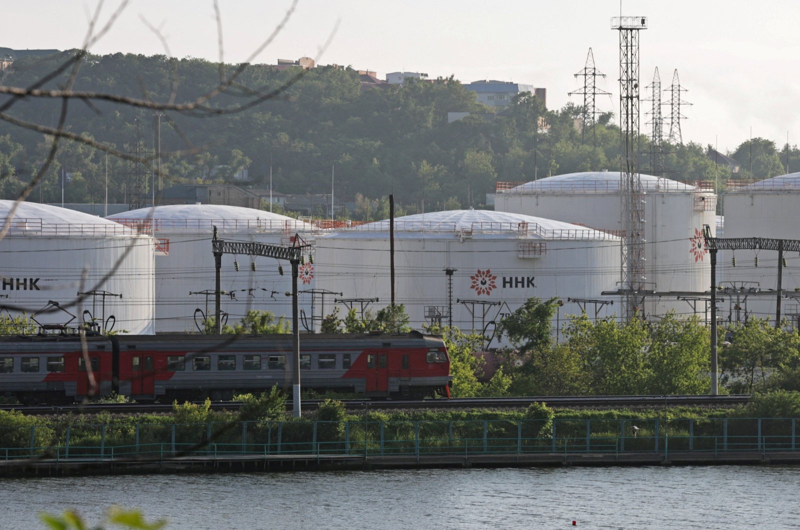 A train moves past oil tanks of the NNK-Primornefteproduct petroleum depot in the far eastern port of Vladivostok, Russia, June 11, 2022. (Reuters Photo)