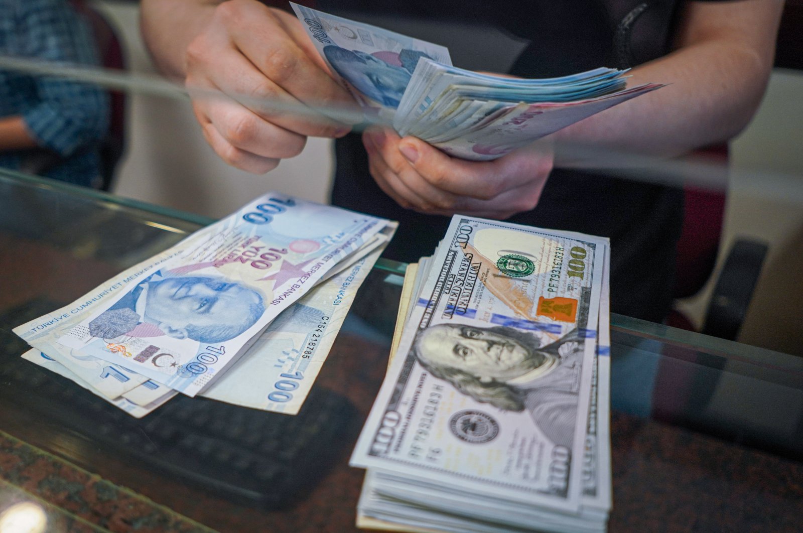 A man at the exchange office counts Turkish lira banknotes in Ankara, Türkiye, Jan. 13, 2022. (Reuters Photo)