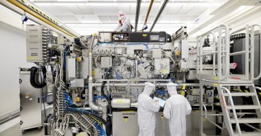 Employees working on the final assembly of ASML's TWINSCAN NXE:3400B semiconductor lithography tool with its panels removed, in Veldhoven, Netherlands, April 4, 2019. (Reuters Photo)