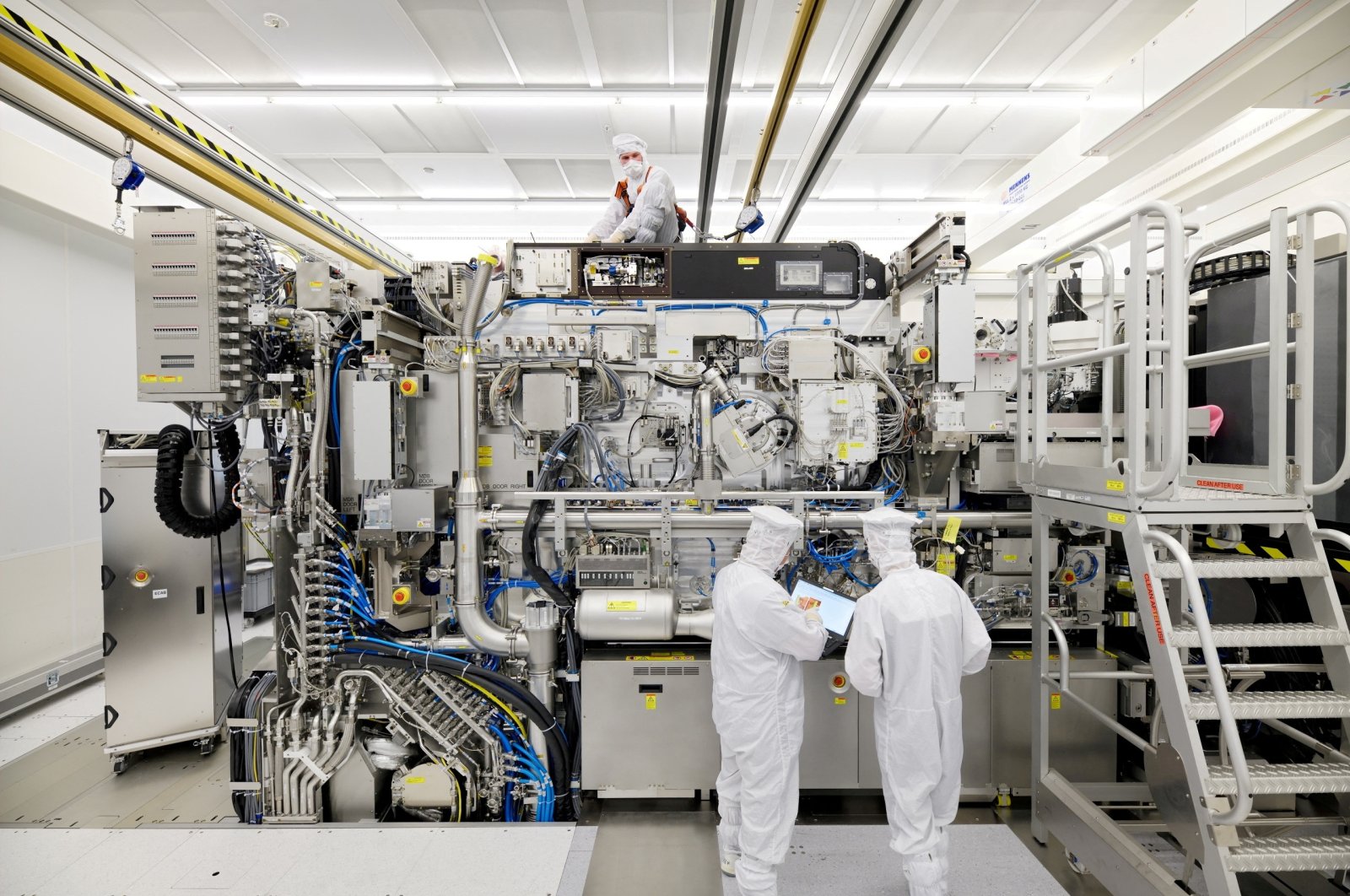 Employees working on the final assembly of ASML&#039;s TWINSCAN NXE:3400B semiconductor lithography tool with its panels removed, in Veldhoven, Netherlands, April 4, 2019. (Reuters Photo)