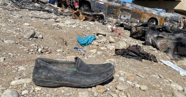 A resident looks at the wreckage of a burnt passenger bus at Bela in the Lasbela district of Balochistan, Pakistan, Jan. 29, 2023. (AFP Photo)