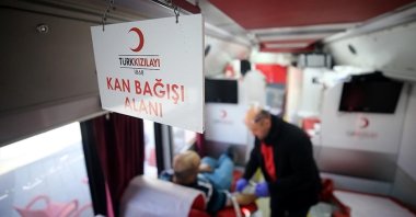 A man is seen donating blood in a Red Crescent (Kızılay) van in this undated photo. (AA Photo)