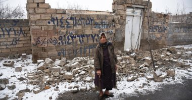 A woman in front of a destroyed building in the Khoy county of West Azerbaijan, Iran, Jan. 29, 2023. (Reuters Photo)