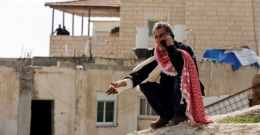 Moussa, the father of Palestinian Khayri Alqam who killed people in a synagogue attack on the outskirts of Jerusalem, speaks on the phone outside the family home as it is sealed off, in A-Tur, East Jerusalem, Jan. 29, 2023. (Reuters Photo)