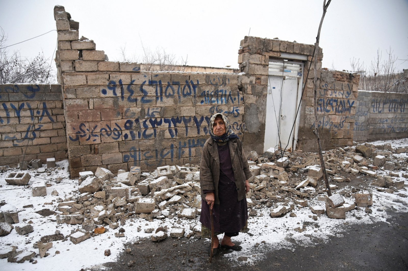 A woman in front of a destroyed building in the Khoy county of West Azerbaijan, Iran, Jan. 29, 2023. (Reuters Photo)