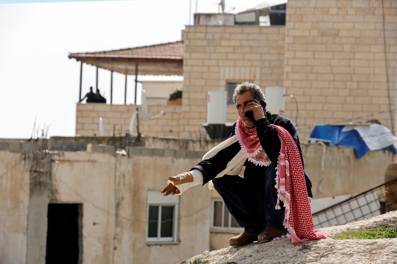 Moussa, the father of Palestinian Khayri Alqam who killed people in a synagogue attack on the outskirts of Jerusalem, speaks on the phone outside the family home as it is sealed off, in A-Tur, East Jerusalem, Jan. 29, 2023. (Reuters Photo)
