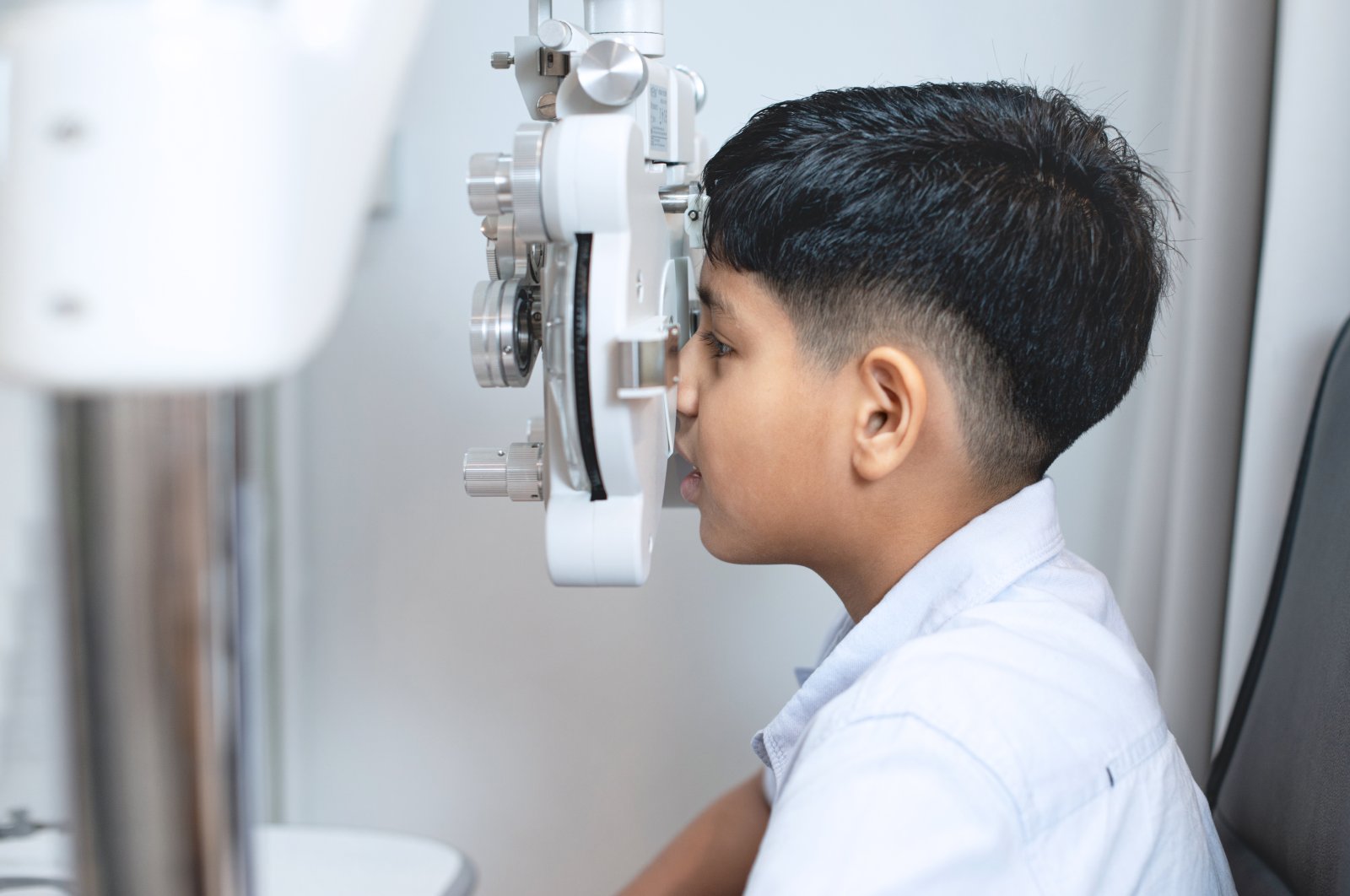 A boy sits for an examination with an optometrist. (Shutterstock Photo)