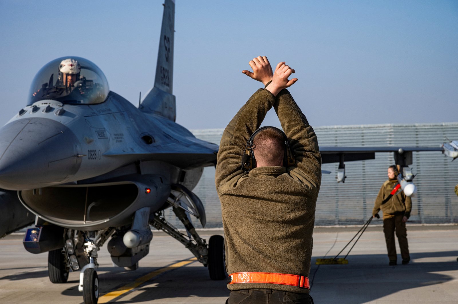 A U.S. Air Force airman marshals an F-16 Fighting Falcon aircraft assigned to the 480th Fighter Squadron, at the 86th Air Base near Fetesti, Romania, Feb. 17, 2022. (Reuters Photo)