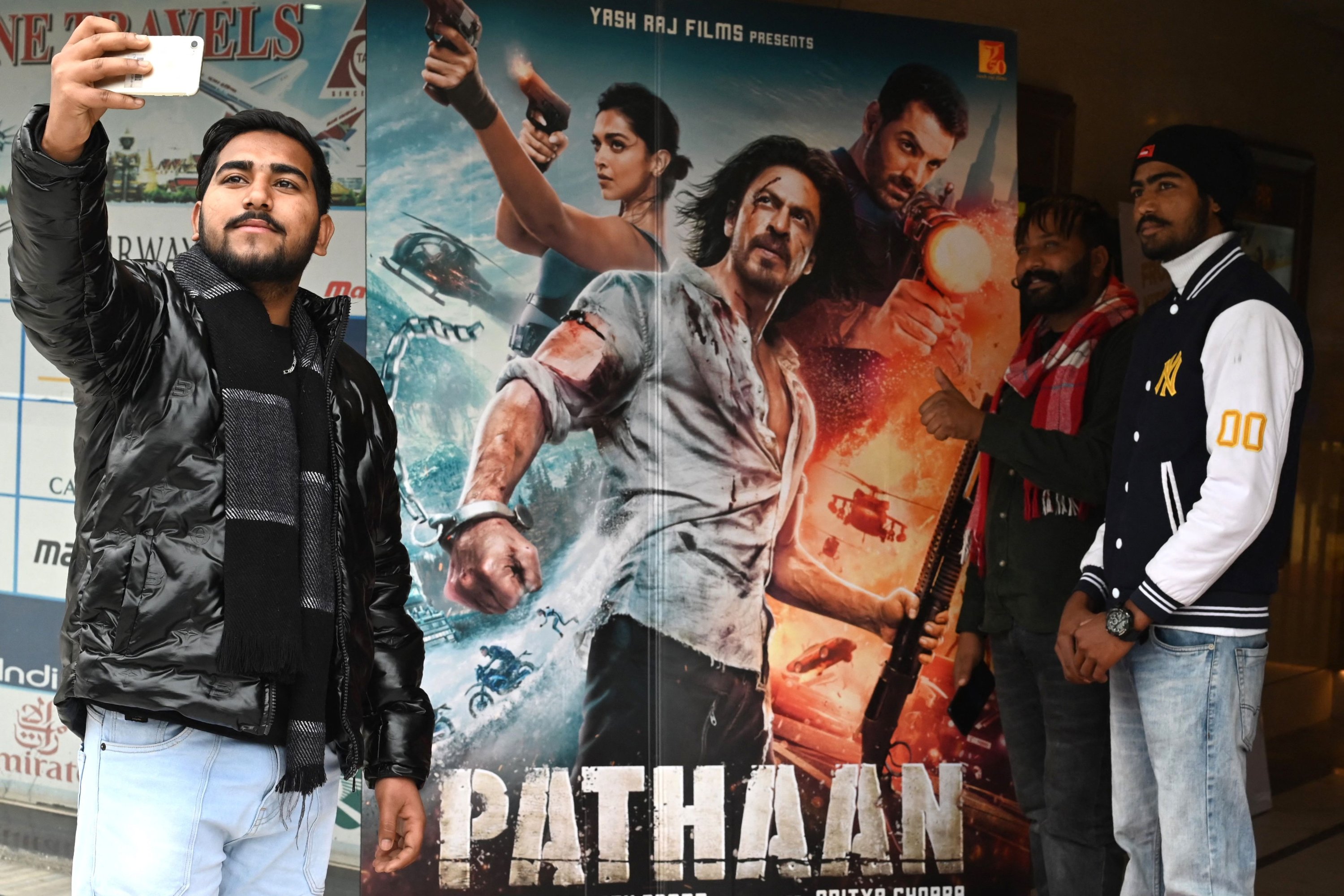 Penonton berfoto di depan poster film Bollywood 