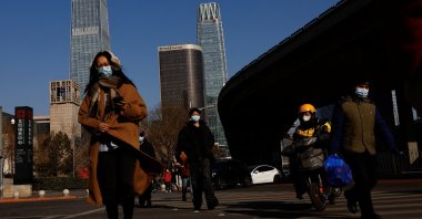 People walk on a street in the Central Business District (CBD) during the morning rush hour following the Chinese Lunar New Year holiday, in Beijing, China, Jan. 30, 2023. (Reuters Photo)