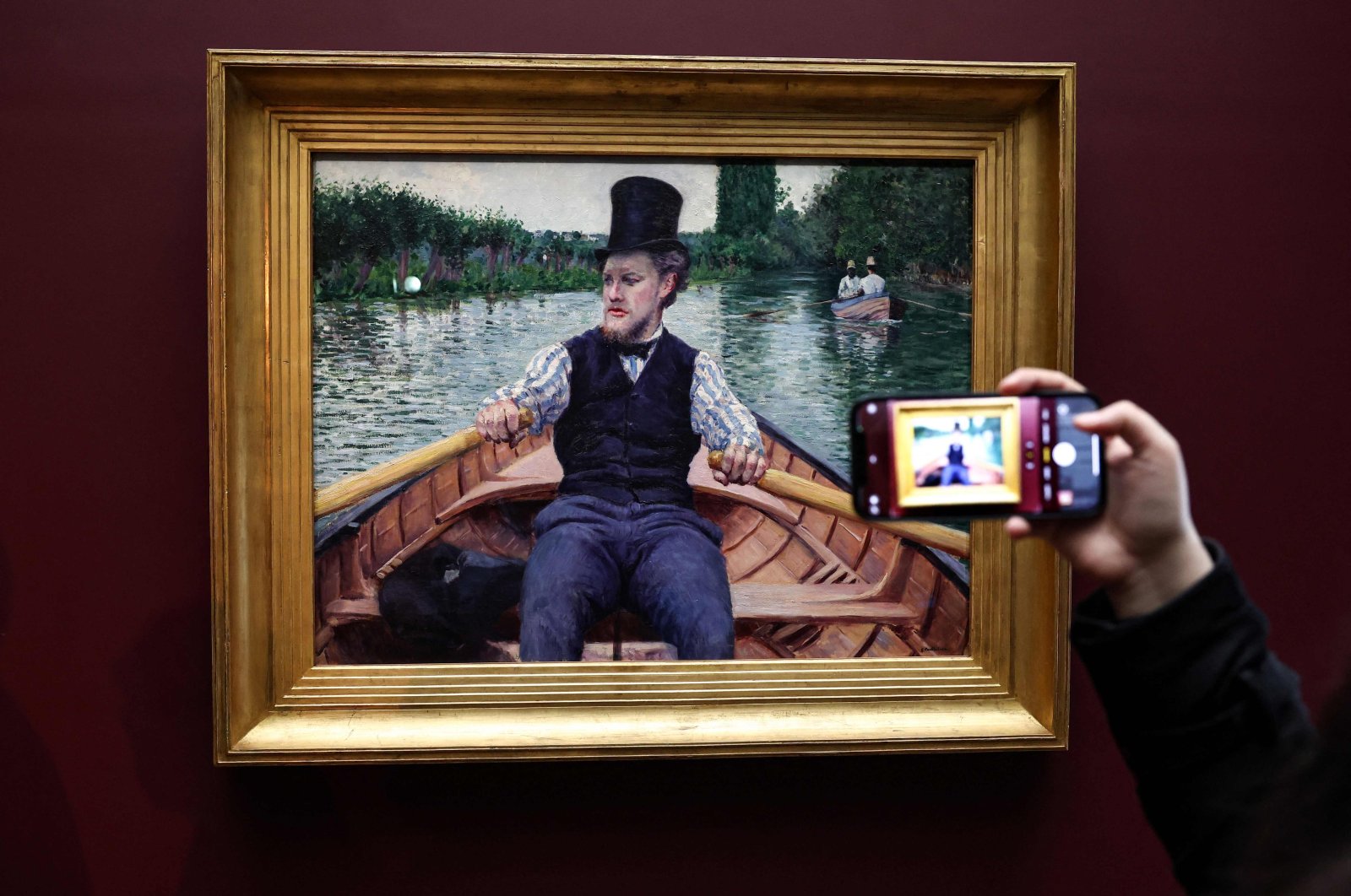 A man takes a picture of the painting &quot;La Partie de bateau&quot; by Gustave Caillebotte, classified as a &quot;national treasure,&quot; which has just joined the Musee d&#039;Orsay, Paris, France, Jan. 30, 2023. (AFP Photo)
