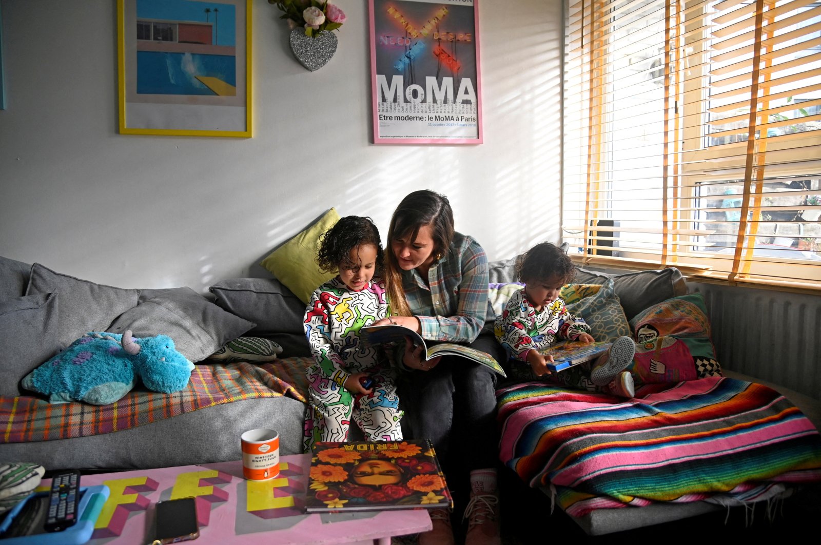 Secondary school teacher Lucy Preston reads with her sons, Sufjan and Elias, during an interview with Reuters ahead of strike action, at her home in London, Britain, Jan. 30, 2023. (Reuters Photo)