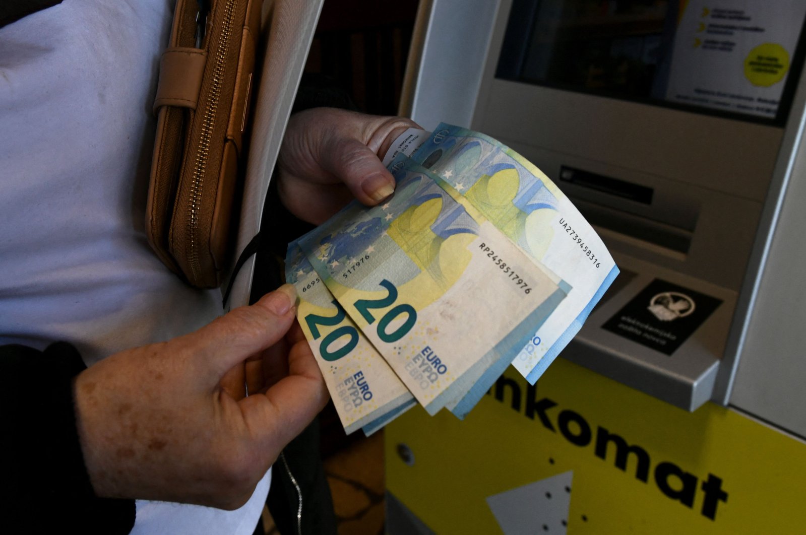 A woman withdraws euro banknotes from an ATM, in Zagreb, Croatia, Jan. 2, 2023. (AFP Photo)