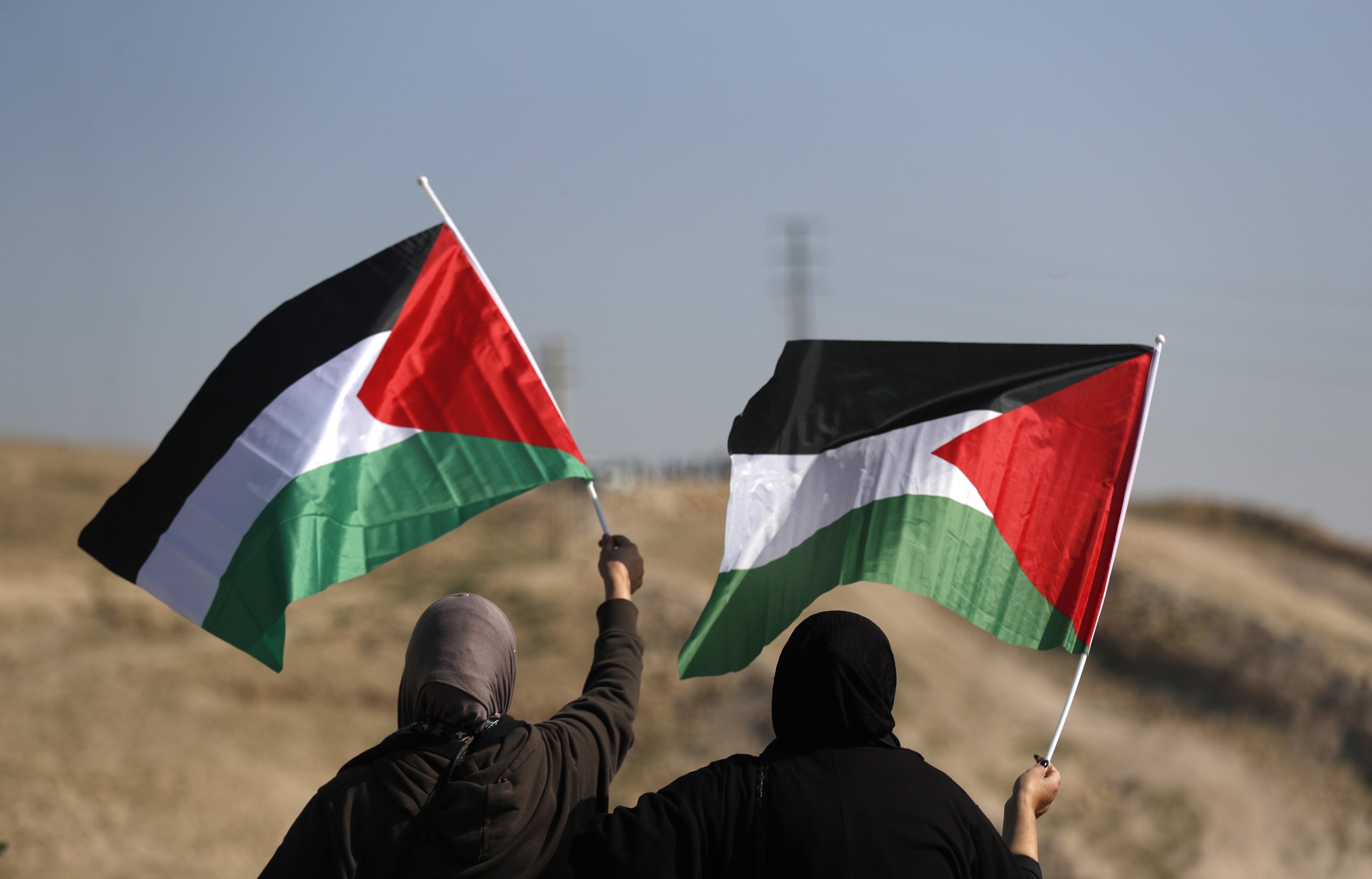 Warga Palestina mengibarkan bendera selama protes terhadap keputusan Israel untuk mengusir komunitas Badui Palestina di Khan al-Ahmar, Tepi Barat yang diduduki, Palestina, 23 Januari 2023. (Foto EPA)