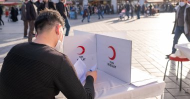 A male blood donation volunteer fills a Turkish Red Crescent form, Eminonu, Istanbul, Türkiye, Feb. 26, 2021. (Shutterstock Photo)