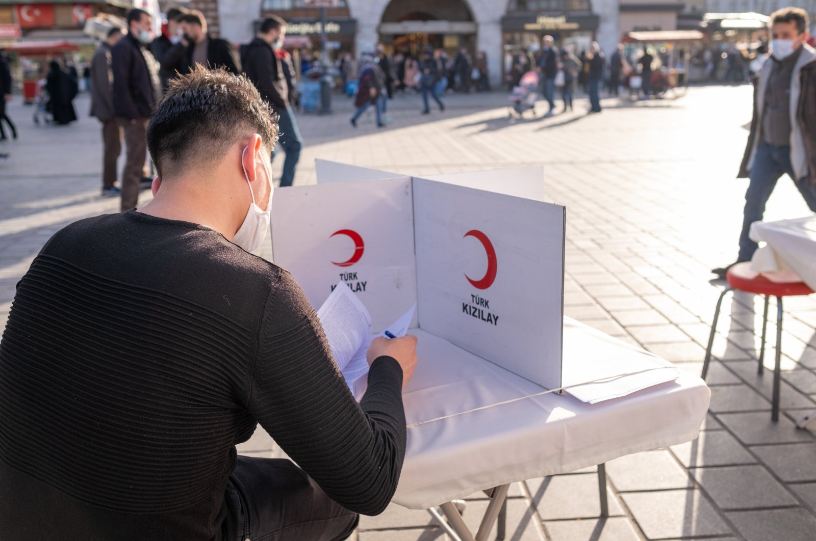 A male blood donation volunteer fills a Turkish Red Crescent form, Eminonu, Istanbul, Türkiye, Feb. 26, 2021. (Shutterstock Photo)