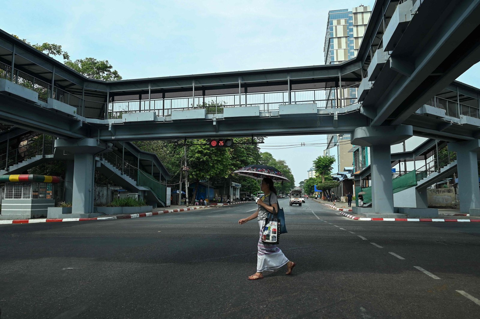 A woman crosses an almost empty street near Sule Pagoda during a &quot;silent strike&quot; to protest and mark the second anniversary of the coup, Yangon, Myanmar, Feb. 1, 2023. (AFP Photo)