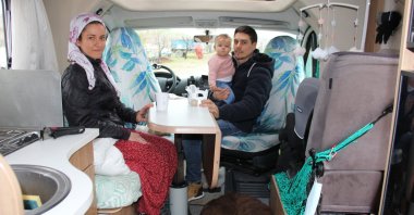 French tourists Annaelle Le Gall and Bastien Tardivel and their baby, Tiana Tardivel Le Gall, are seen in traditional eastern-Turkishwares in their Caravan at Yenigüven village of Adıyaman, Türkiye, Feb. 2, 2023. (IHA Photo)