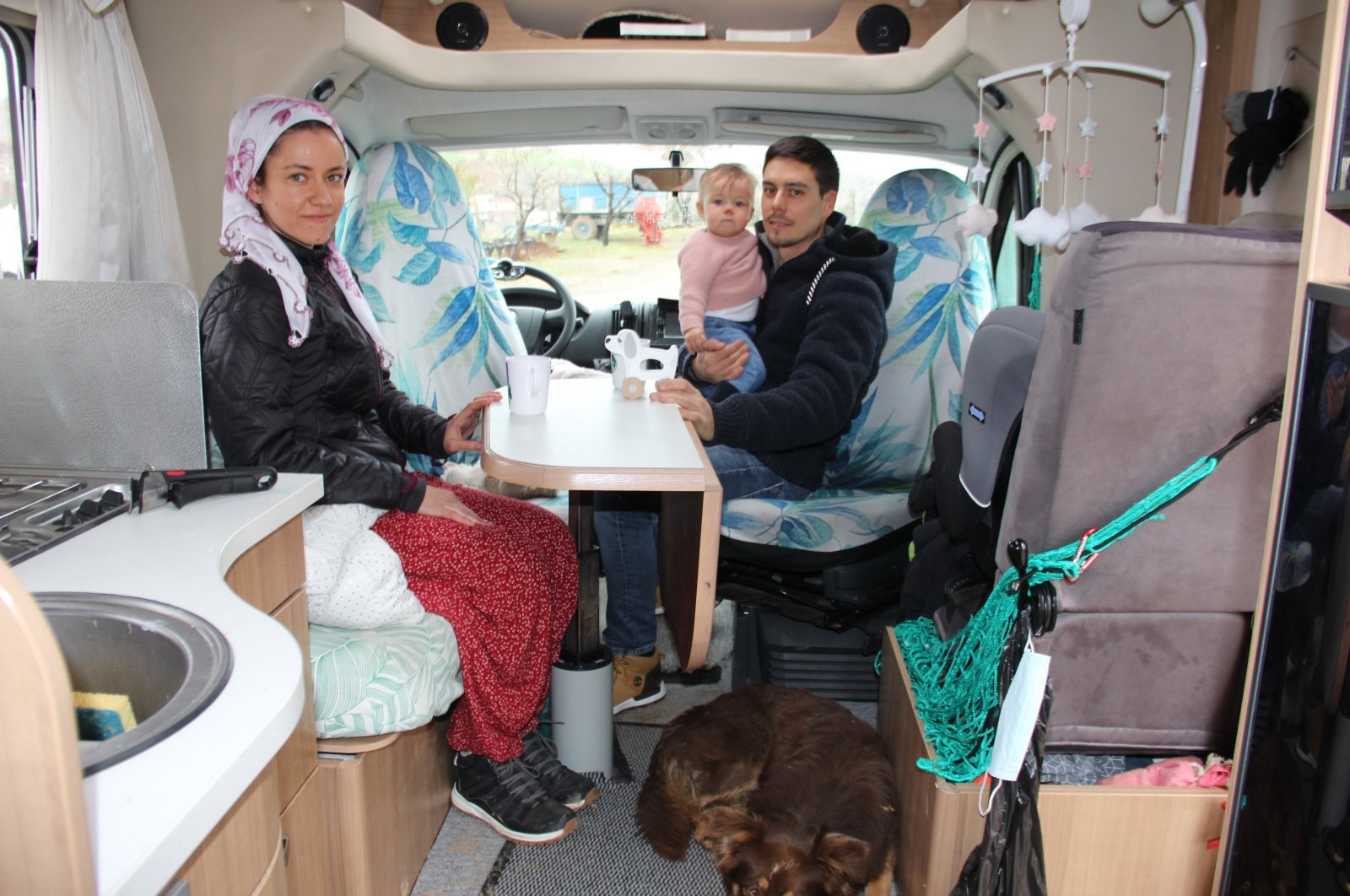 French tourists Annaelle Le Gall and Bastien Tardivel and their baby, Tiana Tardivel Le Gall, are seen in traditional eastern-Turkishwares in their Caravan at Yenigüven village of Adıyaman, Türkiye, Feb. 2, 2023. (IHA Photo)