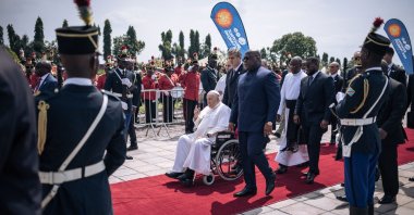 President of the Democratic Republic of the Congo (DRC) Felix Tshisekedi (C-R) walks next to Pope Francis (C-L), seated on a wheelchair, upon the Pope's departure from the Democratic Republic of Congo (DRC), at the N'djili International Airport, Kinshasa, DRC, Feb. 3, 2023. (AFP Photo)