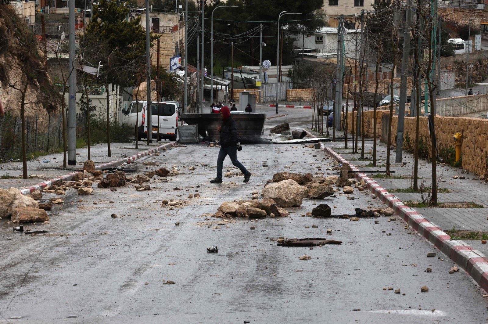 A Palestinian man crosses a blocked street during a strike against house demotions by Israeli authorities in the east Jerusalem neighborhood of Jabal Mukaber, Jan. 31, 2023. (AFP Photo)