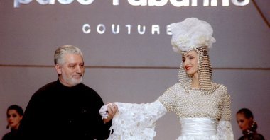 This undated photo shows French Fashion designer Paco Rabanne standing with one of his models at the finale of his show at the Rossiya Hotel in Moscow. (Reuters Photo)