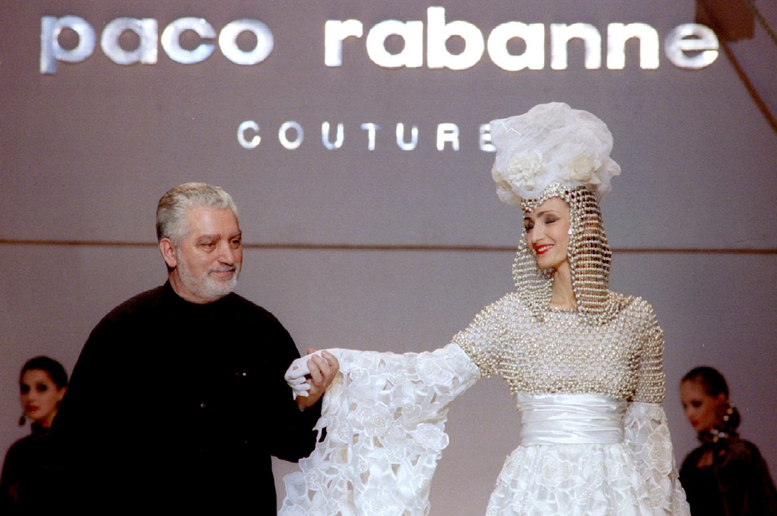 This undated photo shows French Fashion designer Paco Rabanne standing with one of his models at the finale of his show at the Rossiya Hotel in Moscow. (Reuters Photo)