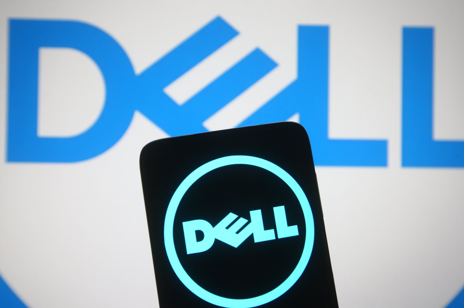 In this photo illustration, the Dell logo is seen on a smartphone and a computer screen in Ukraine, March 15, 2021. (Reuters Photo)