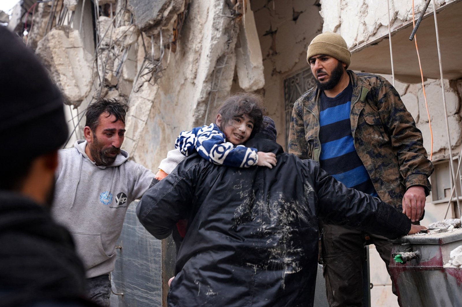 Residents retrieve a small child from the rubble of a collapsed building following an earthquake in the town of Jandaris, northwestern Syria, Feb. 6, 2023. (AFP Photo)